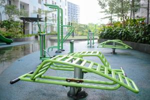 an empty playground with green rides in a park at Kia Servised Apartmen at Grand Sentraland Karawang in Karawang