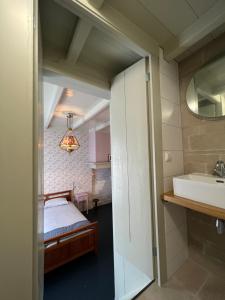 a bathroom with a sink and a bed in a room at Bertha's Hofstede 