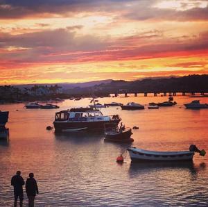 a group of boats in the water at sunset at Mermaid Cottage Teignmouth by the beach SLEEPS 7 in Teignmouth