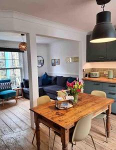 a kitchen and living room with a wooden table at Mermaid Cottage Teignmouth by the beach SLEEPS 7 in Teignmouth