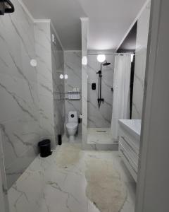 La salle de bains blanche est pourvue de toilettes et d'un lavabo. dans l'établissement К7 family, à Atyraū