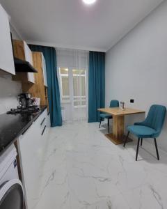 eine Küche und ein Esszimmer mit einem Tisch und Stühlen in der Unterkunft К7 family in Atyrau