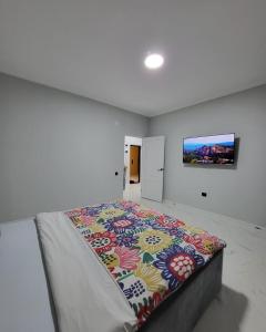 um quarto com uma cama grande e um cobertor colorido em К7 family em Atyrau