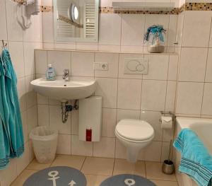 a small bathroom with a sink and a toilet at 13-18, sehr Strandnah, im Herzen Westerlands, Westbalkon, 1 Zi in Westerland (Sylt)