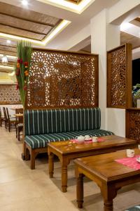 salon z zieloną kanapą i drewnianymi stołami w obiekcie PrideInn Hotel Diani w mieście Diani Beach