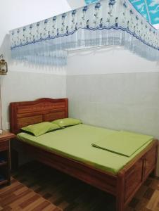een slaapkamer met een bed met een groene matras bij Homestay Nang Nghieng in Kon Tum
