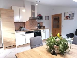 a kitchen with white cabinets and a wooden table at Ferienwohnung Mair in Innsbruck