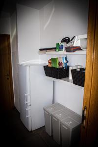 einen weißen Kühlschrank mit zwei Mülleimer in einem Zimmer in der Unterkunft Infiniment Vôtre in Onhaye