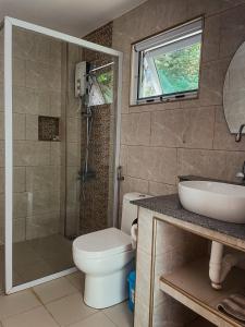 a bathroom with a shower and a toilet and a sink at South Mountain Resort in Siquijor