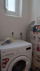 a washing machine in a room with a window at Casa do Bairro 21 in Portel