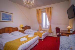 Habitación de hotel con 2 camas y TV en Hôtel Continental en Évian-les-Bains