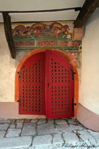 une porte rouge sur le côté du bâtiment dans l'établissement Maison Kobold XVIè siècle, à Wissembourg