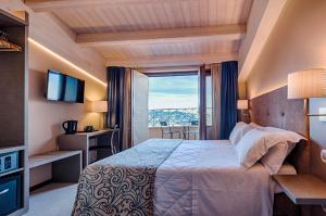 a hotel room with a bed and a large window at La Grotta Hotel in San Marino