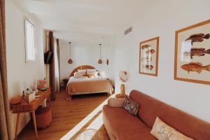 a living room with a bed and a couch at Le Rose Thé in La Ciotat