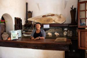 a man sitting at a wooden table in a store at LAMU HOUSE in Lamu