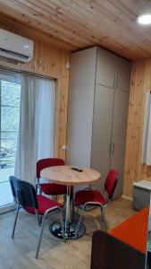 uma mesa e cadeiras num quarto com uma janela em Namelis Šiaurėje em Kaltanėnai
