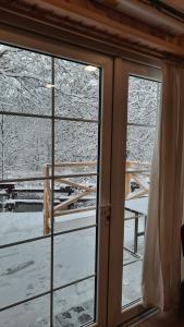 a window with a view of a snow covered yard at Namelis Šiaurėje in Kaltanėnai +1 photo