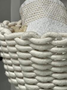 a stack of white towels in a wicker basket at Villa luv in Atlit