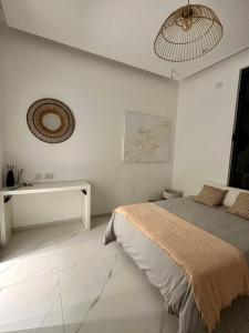 a white bedroom with a bed and a mirror at Villa luv in Atlit