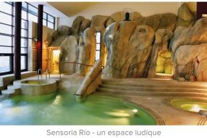 a bathroom with a pool of water in a rock wall at Appartement 4-6 pers proche centre village in Saint-Lary-Soulan