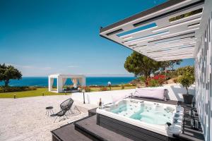 a hot tub on a patio with the ocean in the background at Monte Smith Luxury Villas in Rhodes Town
