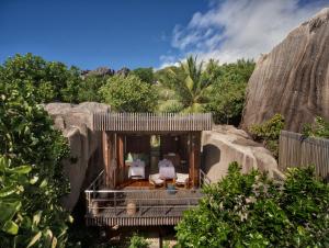 a resort with a room with chairs and rocks at Six Senses Zil Pasyon in Felicité