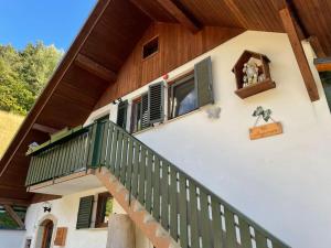 a house with a green balcony and a window at Apartma Butterfly in Škofja Loka