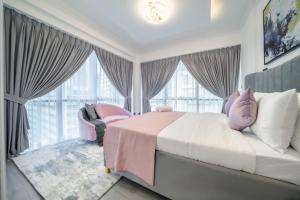 a bedroom with a bed and a chair and windows at Boutique Luxury Living near Palm Jumeirah in Dubai