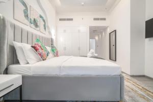 a white bedroom with a large white bed in it at Boutique Luxury Living near Palm Jumeirah in Dubai