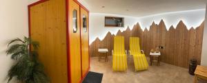 Habitación con sillas amarillas y valla de madera. en Pension Posthansl, en Heiterwang