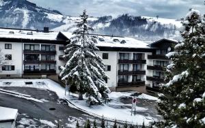 een met sneeuw bedekte kerstboom voor een gebouw bij Appartement Moni XXL 66m2 in Kaprun