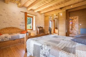 a bedroom with two beds in a log cabin at Les Esseroliettes in Arith