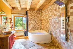 a large bathroom with a tub and a shower at Les Esseroliettes in Arith