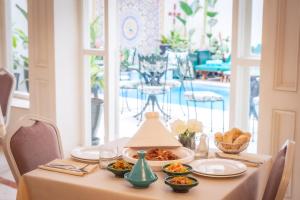 une table avec des assiettes de nourriture au-dessus dans l'établissement Hotel Safia, à Marrakech