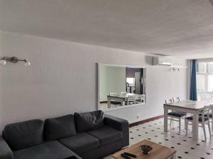 een woonkamer met een bank, een tafel en een spiegel bij Albufeira INN - Casa de Viseu - CORAL T1 in Albufeira