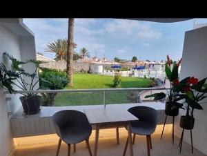une table et quatre chaises dans une chambre avec fenêtre dans l'établissement Apartamento Tamarán 105, à Playa del Ingles