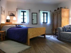 ein Schlafzimmer mit einem Bett, einem Sofa und Fenstern in der Unterkunft Haus Eveline in Gerersdorf bei Güssing