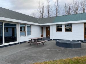 eine Terrasse mit einem Picknicktisch und einem Gebäude in der Unterkunft Laugavellir - House in Kleppjárnsreykir