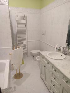 Baño blanco con lavabo y aseo en La casa di Carolina, en Citerna