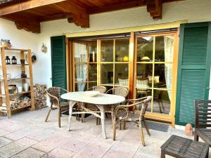 a table and chairs on the patio of a house at FeWo Flair in Rottach-Egern