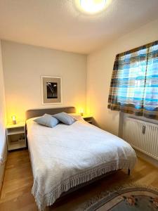 a bedroom with a bed with two pillows and a window at FeWo Flair in Rottach-Egern