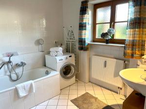 a bathroom with a washing machine and a sink at FeWo Flair in Rottach-Egern