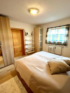 Un dormitorio con una cama grande y una ventana en FeWo Flair, en Rottach-Egern