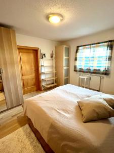 a bedroom with a large bed and a window at FeWo Flair in Rottach-Egern