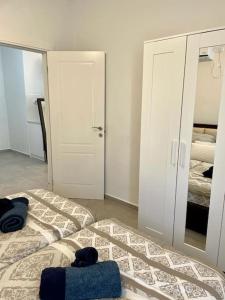 a bedroom with two beds and a closet and a mirror at Gep's on Lachish in Beit Shemesh