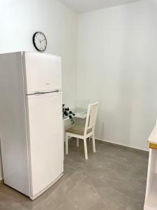 een koelkast in een keuken met een stoel en een klok bij Gep's on Lachish in Bet Shemesh