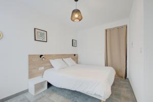 a bedroom with a white bed and a pendant light at Les forges 2 pièces RDC in Avoine