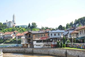 a group of buildings next to a river at Apartman MT in Kiseljak