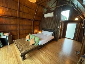 a bedroom with a bed in a wooden room at Villa Baan Pak Pra in Ban Pak Pra (1)