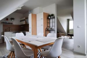 - une cuisine et une salle à manger avec une table et des chaises dans l'établissement Vienna's Nature Corner - charming rooftop family apartment, à Gerasdorf bei Wien